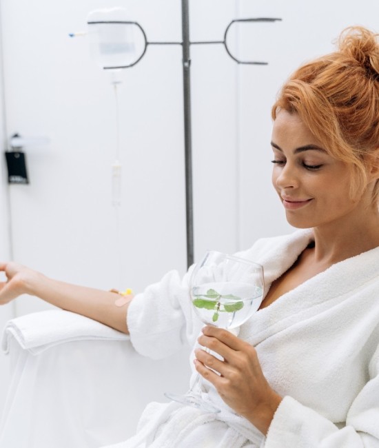waist-up-portrait-view-charming-woman-white-bathrobe-sitting-armchair-receiving-iv-infusion-she-is-holding-glass-lemon-beverage-smiling (1) waist-up-portrait-view-charming-woman-white-bathrobe-sitting-armchair-receiving-iv-infusion-she-is-holding-glass-lemon-beverage-smiling (1)